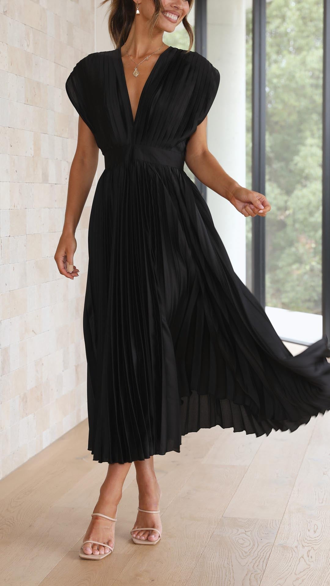 Full silhouette of pleated midi dress showing graceful movement and structured bodice