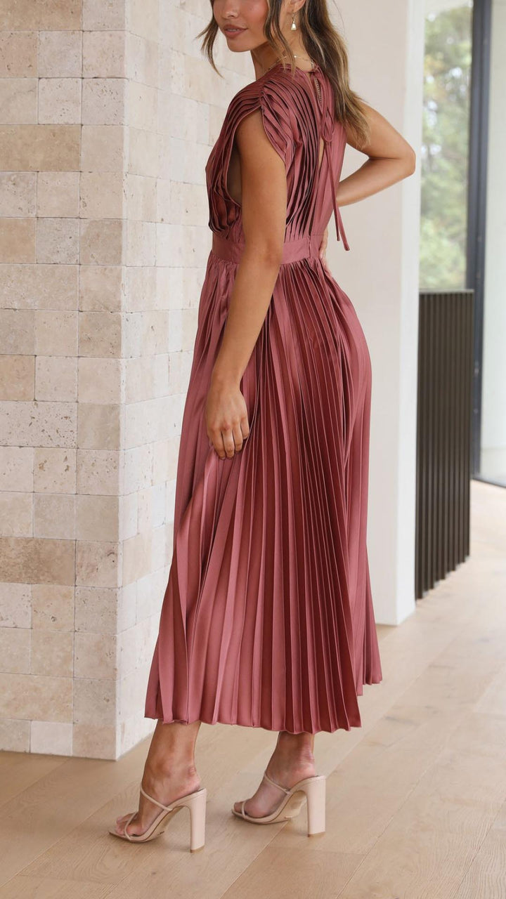 Side angle of V-neck pleated midi dress displaying graceful drape and flowing silhouette