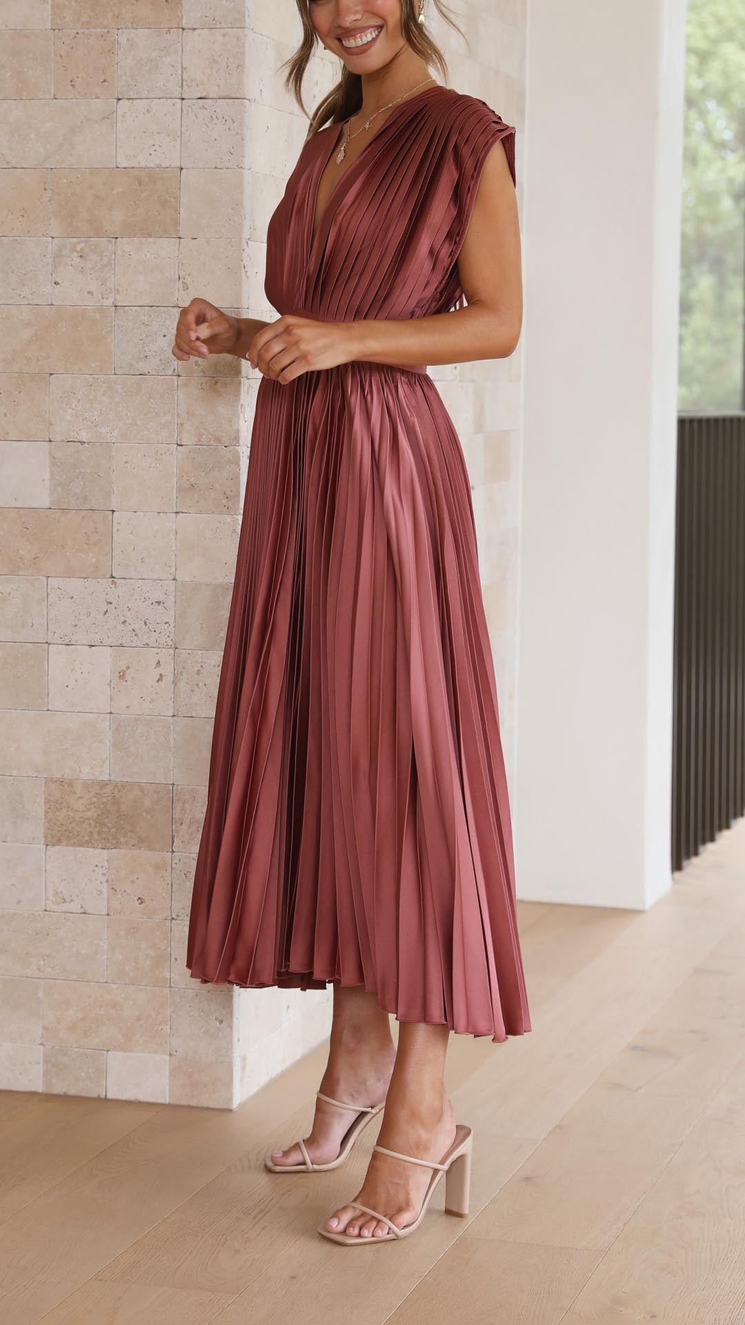 Close-up of pleated bodice detail on women's midi wedding guest dress with structured cap sleeves