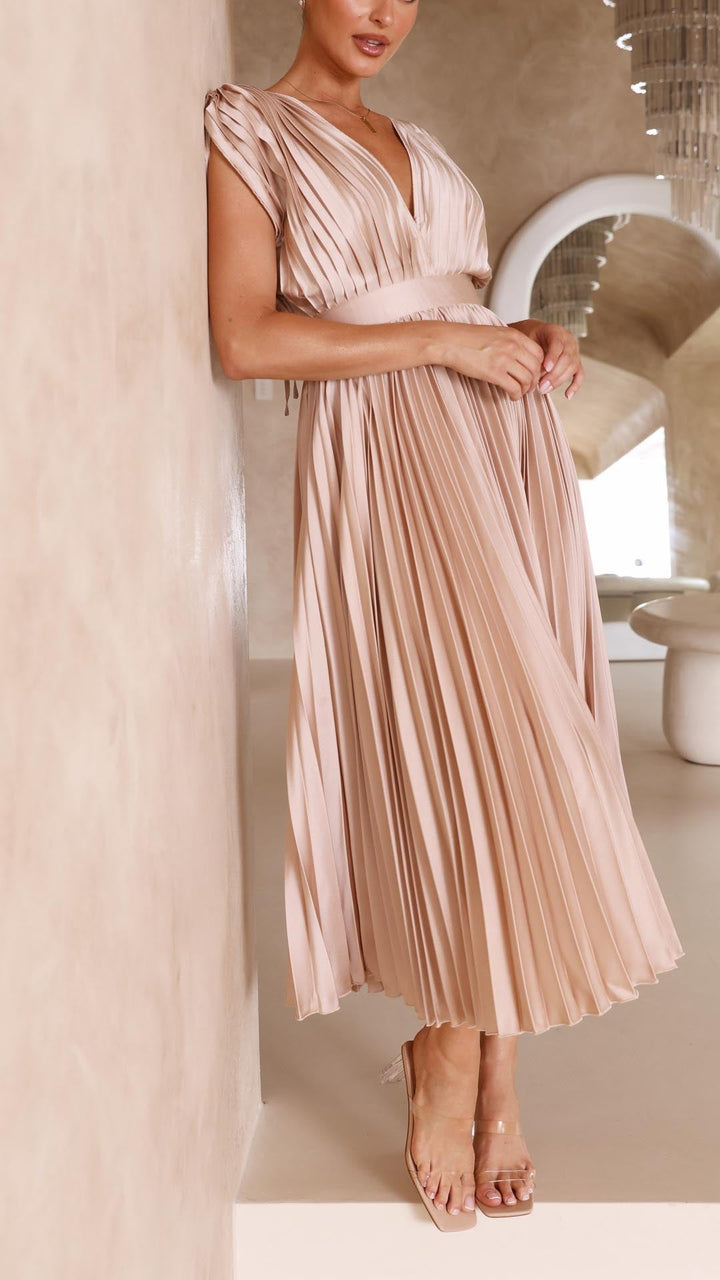 Model wearing pleated wedding guest dress showing midi length and flattering V-neckline