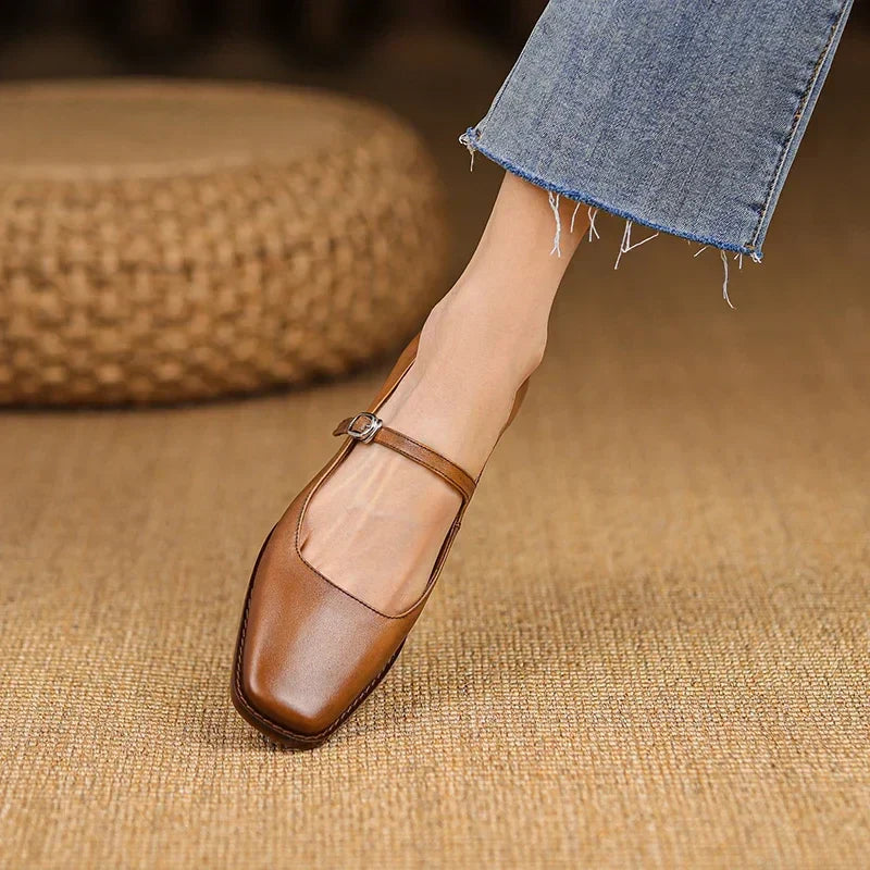 Close-up view of women's strap block heel shoes showing rounded toe and smooth finish detail