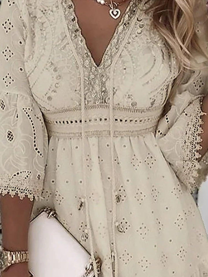 Close-up view of the V-neckline and delicate eyelet lace fabric on the Boho Mini Dress with button-front closure