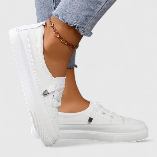 Detail shot of lace-up closure and structured upper on white platform trainers