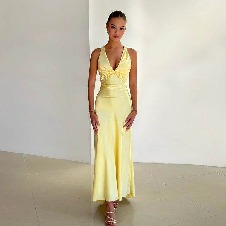 Side profile of crossover neckline wedding guest dress with fitted waist and ankle-length hem