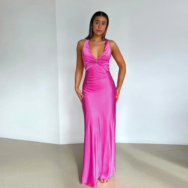 Full-length crossover neckline wedding guest dress styled with strappy heels for evening occasion