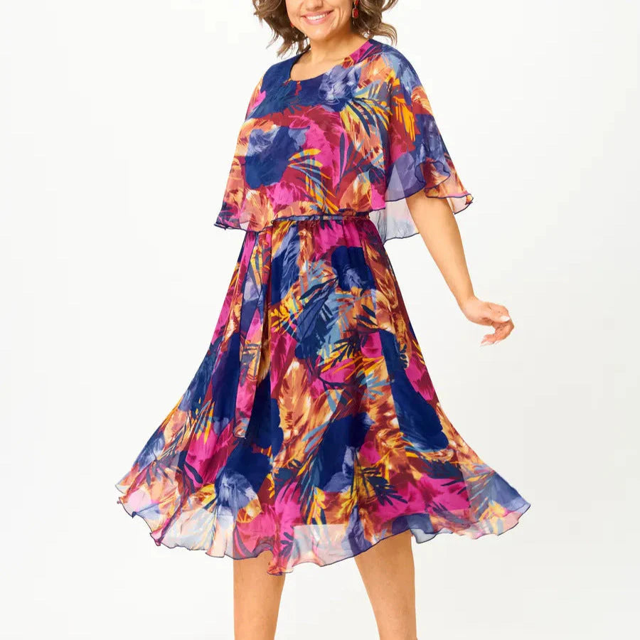 Side view of plus size chiffon dress with cape sleeves and elasticated waist creating relaxed A-line shape for comfortable fit