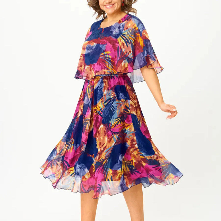 Side view of plus size chiffon dress with cape sleeves and elasticated waist creating relaxed A-line shape for comfortable fit