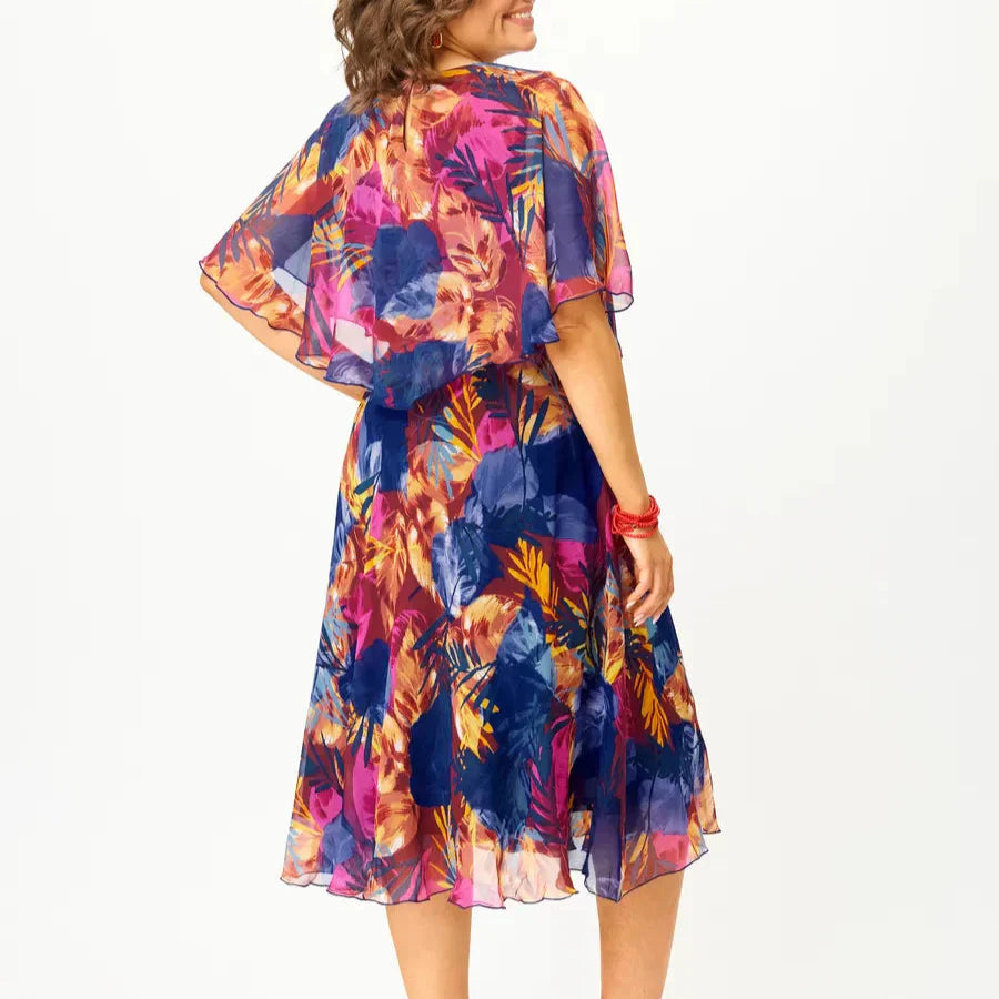 Detail shot of chiffon dress neckline and cape sleeve construction showing lightweight drape and floral pattern arrangement