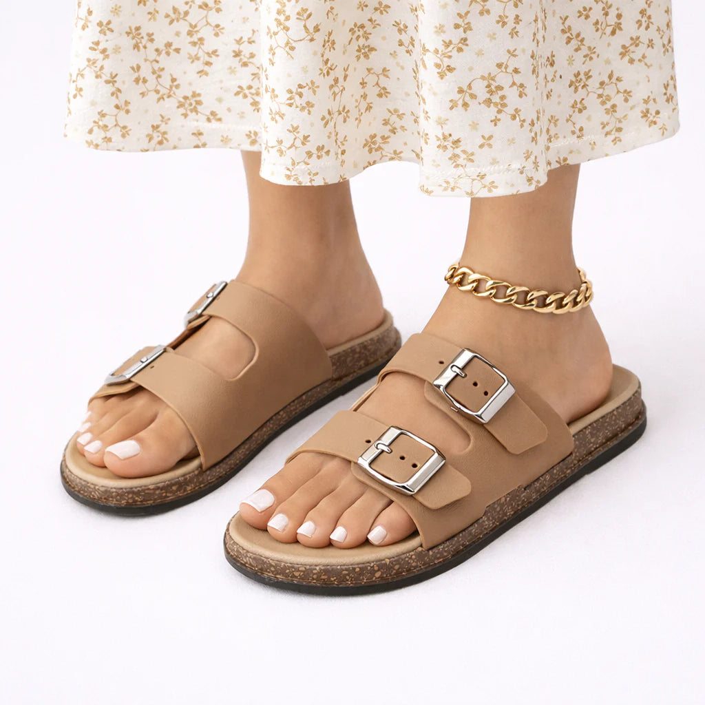 Women's tan buckle sandals with double adjustable straps and cork-effect sole worn with floral midi dress