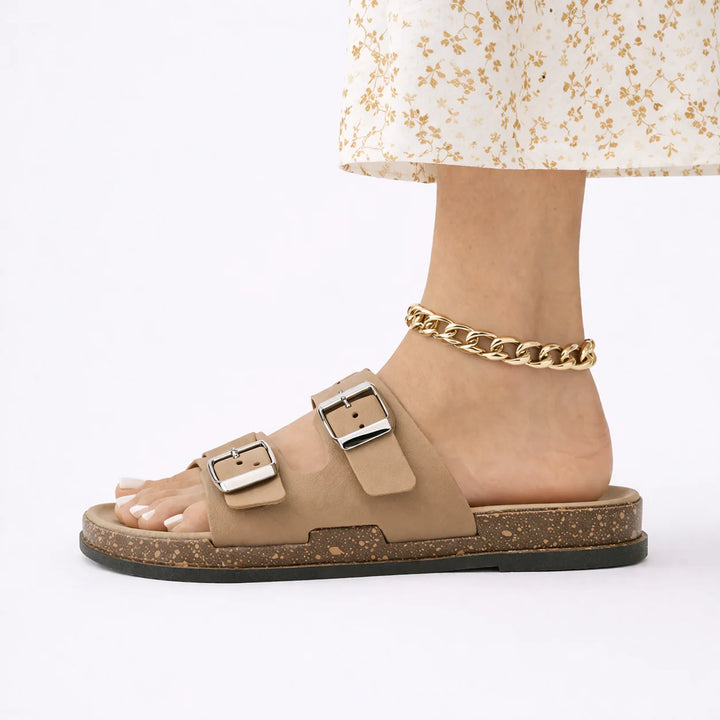 Close-up of women's buckle sandals showing silver-tone buckle fastenings and contoured footbed design