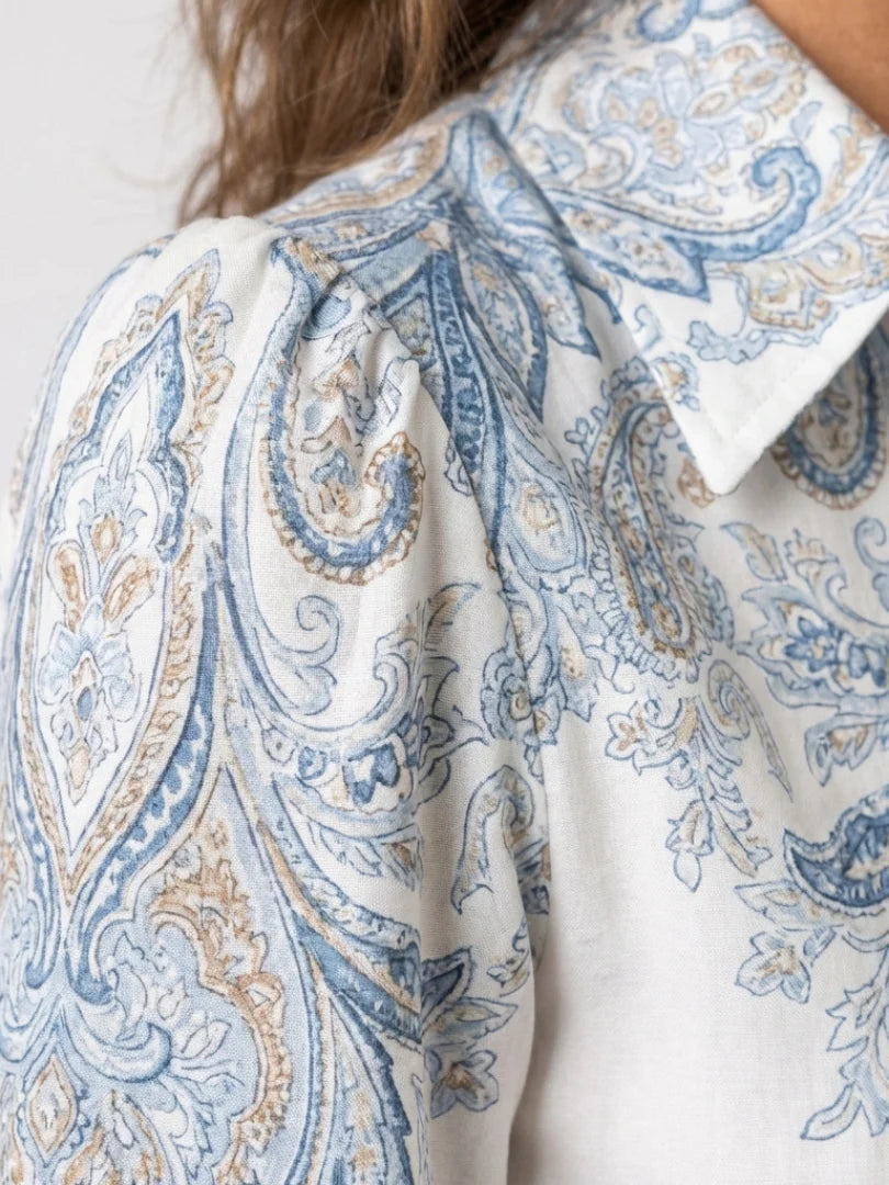 Front view of high neck printed maxi dress showing structured bodice, button-front closure, and flowing skirt with paisley pattern