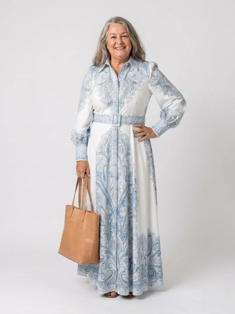 Side angle of belted waist and flowing maxi-length skirt on high neck printed dress